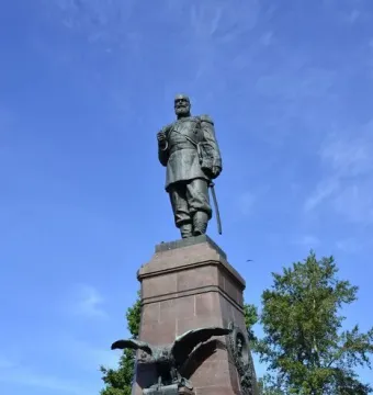 Monument of Alexander III on a tall stone pedestal with bronze reliefs and a double-headed eagle.