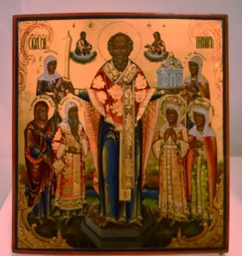 Saint Nicholas of Mozhaysk icon showing a central bearded figure with outstretched hands, flanked by smaller saints and symbolic offerings.