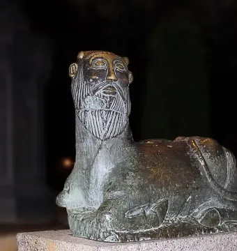 Bicha of Balazote sculpture with a bearded human head and reclining animal body on a stone base.