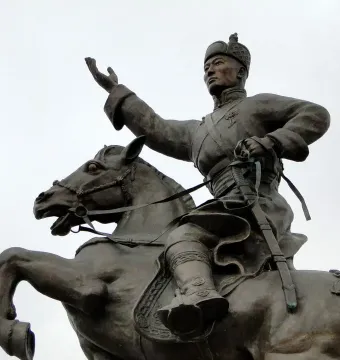 Bronze statue of Damdin Sükhbaatar on a rearing horse, with one arm raised and a sword in hand.