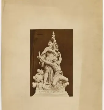 Sepia photograph of the La Défense de Paris sculpture group, showing a draped female figure standing over a kneeling soldier.