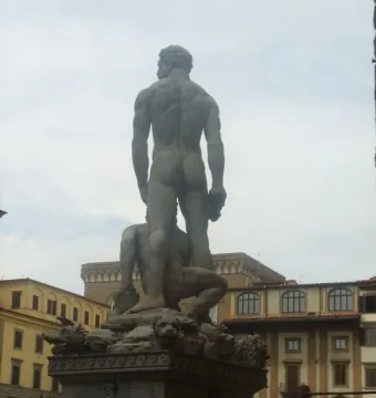 Hercules and Cacus seen from behind, with the muscular standing figure atop another figure on an ornate pedestal.