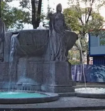 Nornenbrunnen fountain with three draped female figures around a large bowl and smaller basins below