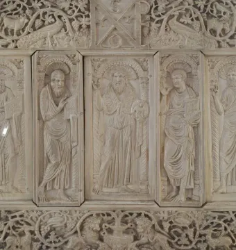 Relief panel from the Throne of Maximian with five haloed figures in vertical sections, surrounded by carved vines and animals.