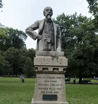 Stone bust of Ernesto Teodoro Moneta on a pedestal in a grassy park