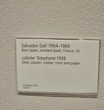 Information label for Lobster Telephone by Salvador Dalí mounted on a wall.