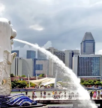 The Merlion statue spouts water into the bay with Singapore’s skyline behind it.