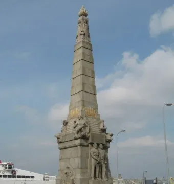 Titanic Engine Room Heroes Memorial stone monument with carved figures and a flame-like top