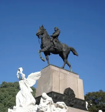 Bartolomé Mitre Monument showing a dark equestrian sculpture atop a tall stone pedestal with carved figures at the base.