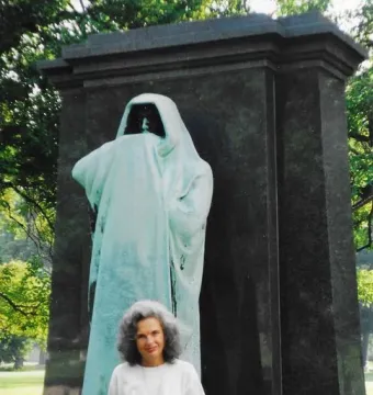 Eternal Silence sculpture, a hooded bronze figure standing before a dark stone slab.