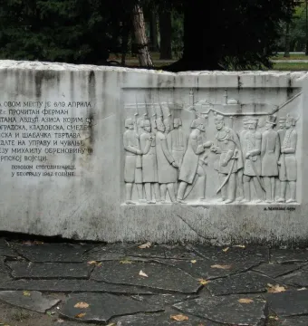 Keys Handover Memorial stone monument with a relief of historical figures and Cyrillic inscription