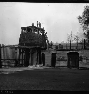 The Marly Horses surrounded by wooden scaffolding and a large conical temporary enclosure near an ornate fence and stone wall.