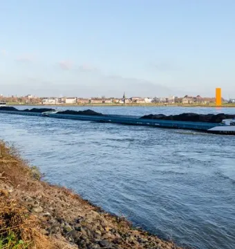 The Rhine Orange stands on the distant riverbank beside the Rhine in Duisburg.