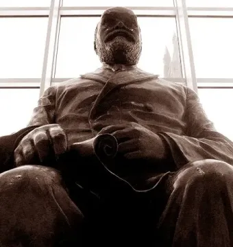 Timothy Eaton statue shown in low-angle silhouette against a bright window