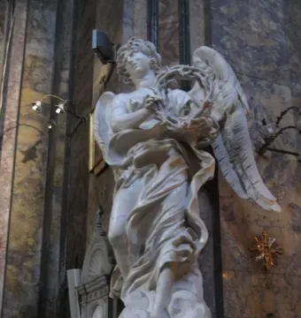 Bernini\'s Angel with the Crown of Thorns, a white marble angel holding a thorny wreath and looking upward.