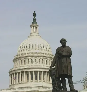 James A. Garfield Monument with a bronze statue of James A. Garfield in front of the U.S. Capitol dome and columns