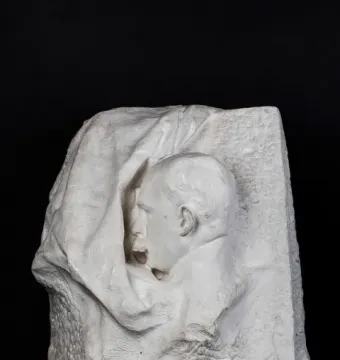 Octave Mirbeau plaster bust in profile, facing left with an open mouth, emerging from a rough draped block.