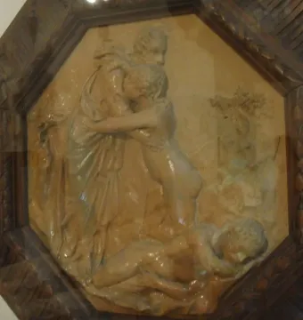 Creation of Eve terracotta relief showing a draped figure embracing a smaller nude figure above a reclining nude figure.