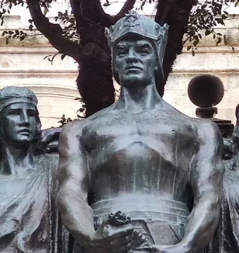 Upper figures of the Great Siege Monument showing a crowned male figure flanked by two draped female figures.