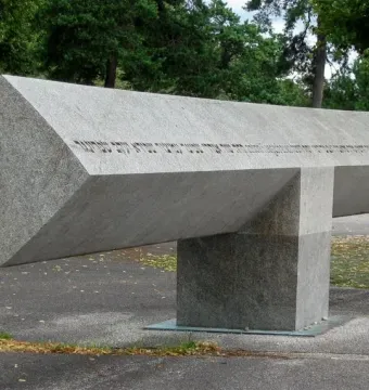 Klagebalken memorial with a long stone beam balanced on a central block outdoors.