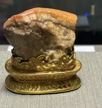Meat-Shaped Stone carved like a piece of pork belly on an ornate gold stand.