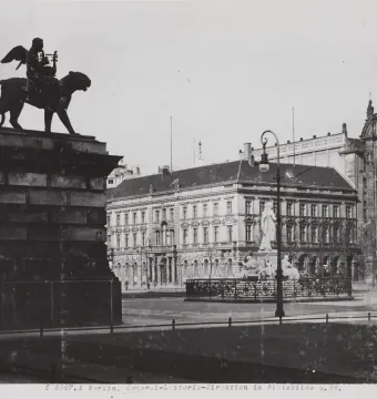 Schiller Monument with a winged figure riding a panther atop a tall pedestal, surrounded by classical statues and historic buildings.