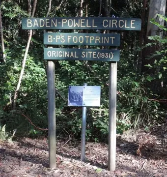 Concrete slab with a foot-shaped indentation beneath a Baden-Powell Circle signpost.