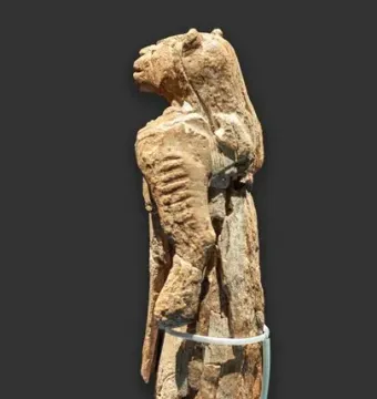 Lion-man statue shown from the left side, with a lion-like head and fragmented human body.