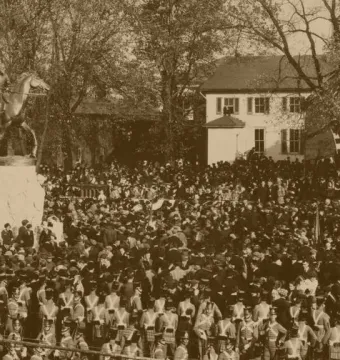 Stonewall Jackson equestrian statue on a pedestal with a large crowd gathered around it.