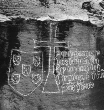 Stone inscription on the Padrão de Ielala with a shield emblem, a large cross, and carved text.