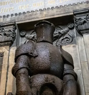 Wehrmann in Eisen, a dark armored knight statue with a sword held horizontally across its lower body.