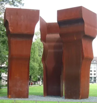Buscando la Luz II by Eduardo Chillida, three rusted steel sculptures standing in a grassy park.