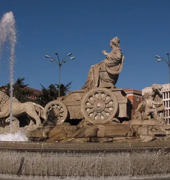 Cibeles Fountain with the goddess seated in a chariot drawn by lions, with water spraying around the base.