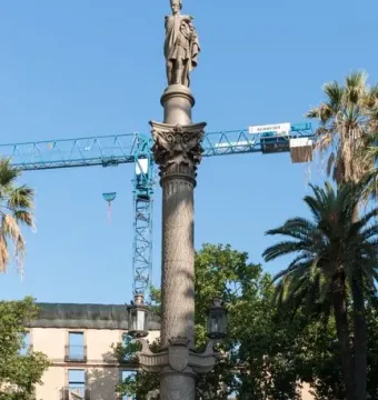 Galceran Marquet Monument with a stone column and standing figure, set in a fountain with bronze marine figures in Barcelona.