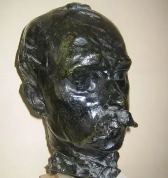 Bust of Octave Mirbeau with a prominent mustache on a tiered stone base