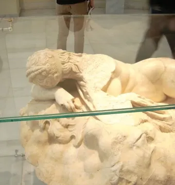 Sleeping Maenad reclining marble statue of a nude woman resting her head on her arm, with visible repair patches.