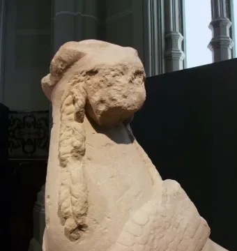 Detail of the Sphinx of Agost showing the eroded human-like head and winged upper body in limestone.