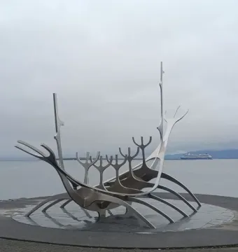 The Sun Voyager sculpture stands beside the water with a cruise ship in the background.