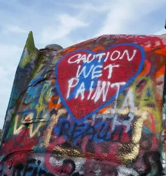 Graffitied Cadillac Ranch car tailfin with a red heart reading \