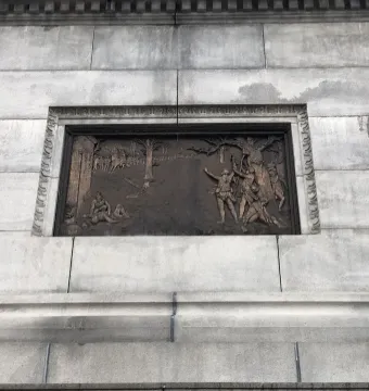 Bronze relief panel on the Trenton Battle Monument showing a scene with several figures around a tree.