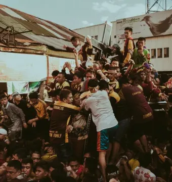 The Black Nazarene statue is carried through a dense crowd of devotees in the street.