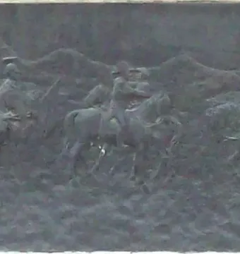 Bronze relief on the General Espartero Monument showing mounted military figures crossing a rugged landscape.