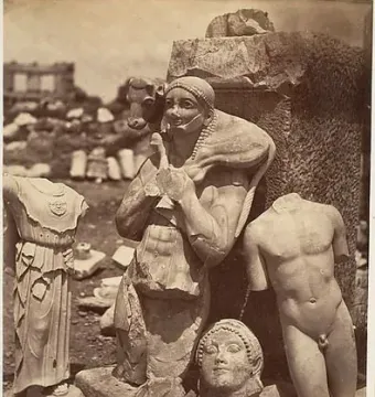 Weathered marble Kritios Boy torso among ancient stone fragments