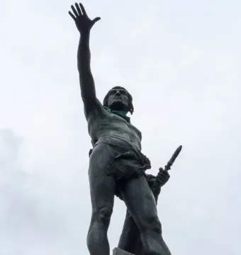 Monument to Viriato showing a barefoot warrior statue on a stone base, raising one hand and holding a dagger.