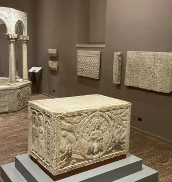 Baptistry of Callistus, an octagonal stone baptismal font with slender columns, arches, and carved decorative patterns.