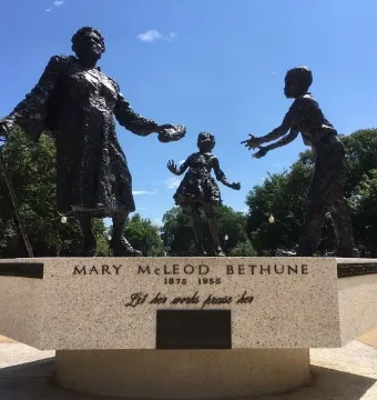 Mary McLeod Bethune Memorial bronze statue of Mary McLeod Bethune with two children reaching toward her.
