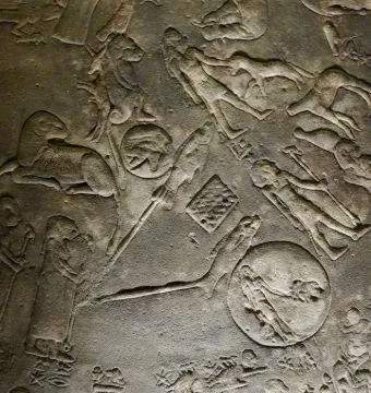 Close-up of the Dendera Zodiac showing weathered stone relief carvings with figures, animals, and celestial symbols.