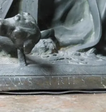Close-up of a weathered sculpture base in the Mausoleum of Prince Ernst, showing the inscription \