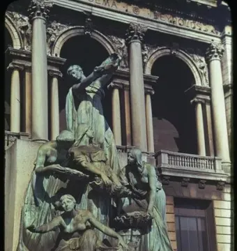 The Fountain of the Great Lakes sculpture with five draped female figures set before a classical stone building.