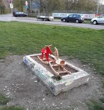 Holbeinpferd concrete stall with a red rocking moose and a wooden rocking horse inside
